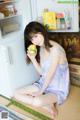 A woman sitting on the floor holding a box of orange juice.