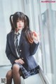 A woman in a school uniform sitting on a window sill.