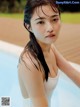 A woman in a white bathing suit sitting in a pool.