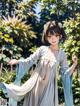 A woman in a blue and white kimono standing in a forest.