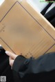 A person holding a cardboard box with chinese writing on it.