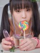 A young girl holding a lollipop in her mouth.