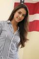 A woman standing in front of an American flag.